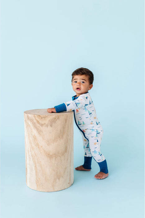 Standing Baby Model Wearing Kai Sailboat Print Blue Bamboo Zip Romper Footie
