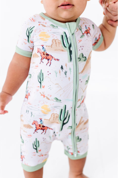 closeup of baby model wearing Bird & Bean Bamboo Shortie Romper Onesie with Billy Cowboy Western Print