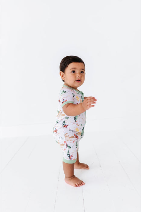 side profile view of baby model wearing billy cowboy western print shortie zip romper onesie