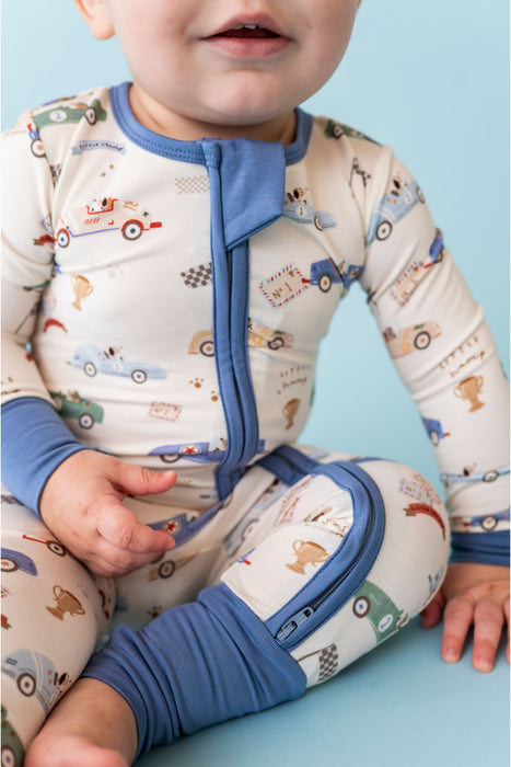 Baby wearing pajamas with car pattern on a light blue background Bird and Bean Kids 
