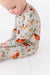 Baby wearing a long-sleeve zip PJ sleeper with horses pattern background  -Bird adn Bean Bamboo Baby Wear