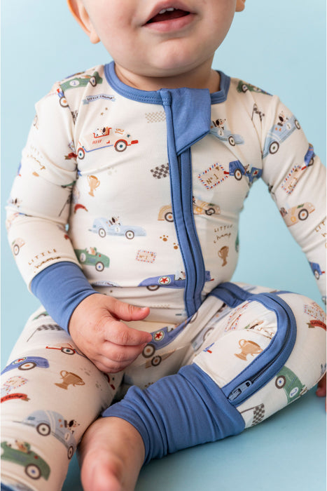 Baby wearing a car-themed bamboo romper with blue accents on a light blue background Bird and Bean Kids 