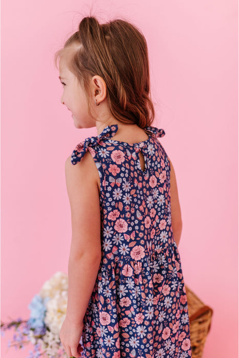 Young girl wearing a bamboo summer floral tank dress against a pink background | Bird and Bean Kids