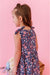 Young girl wearing a bamboo summer floral tank dress against a pink background | Bird and Bean Kids