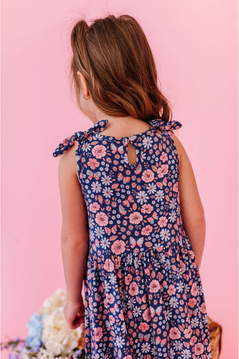 Young girl wearing a floral  print sundress against a pink background | Bird and Bean 