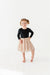 Young girl wearing a black long-sleeve top and polka dot skirt on a white background | Bird and Bean Holiday Shop