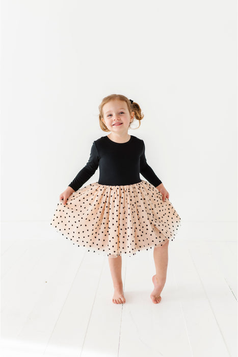 Child wearing a black long-sleeve bamboo top and polka dot skirt on a white background | Bird and Bean Holiday Shop 