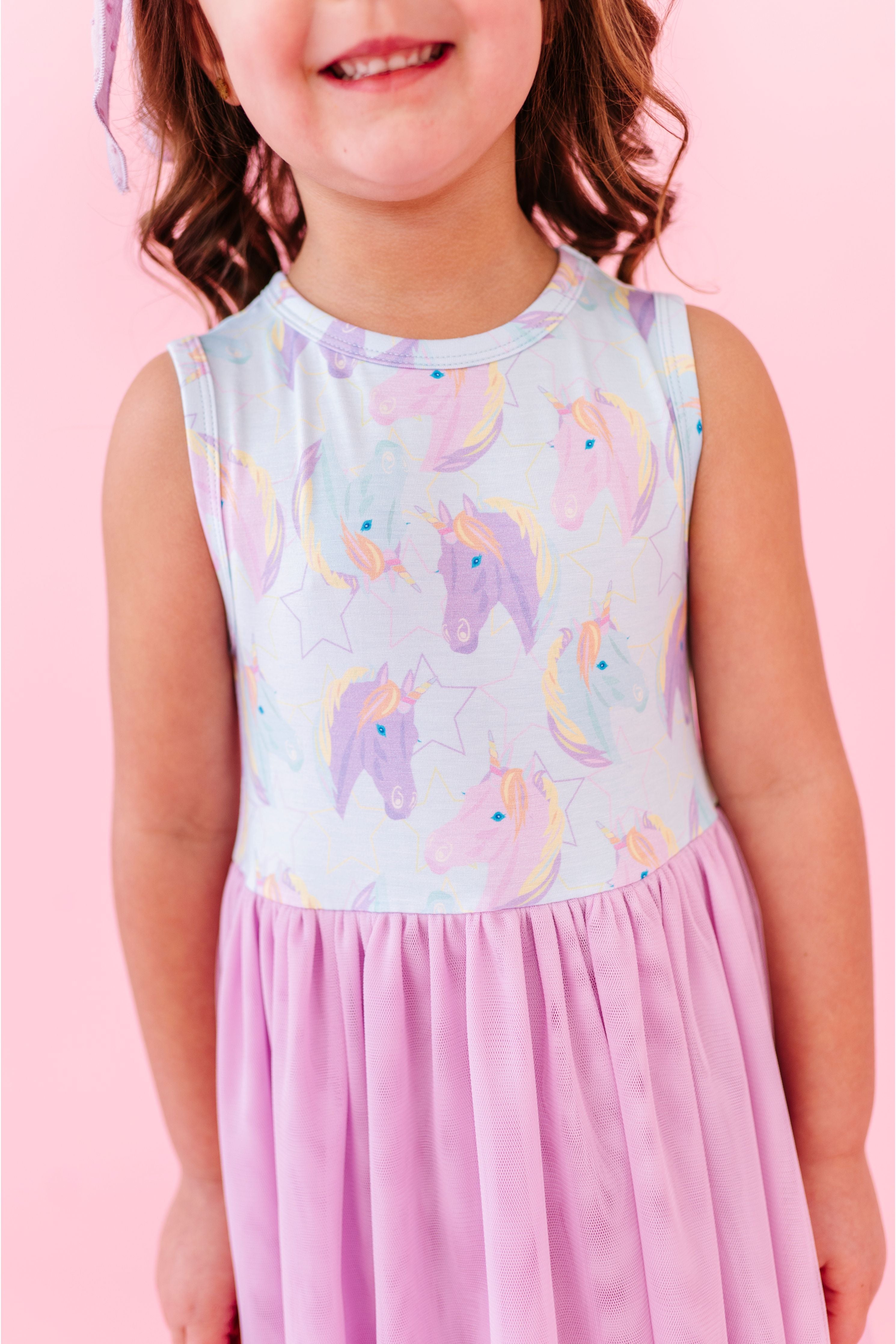Child wearing a tulle skirt bamboo dress with unicorn pattern on a pink background | Bird and Bean Kids