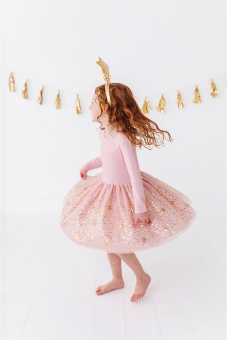 Young girl in a pink bamboo dress with gold sequins standing against a white background with gold decorations. | Bird and Bean Holiday Shop 