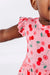Child wearing a pink flower print outfit with cherry pattern on a white background | Bird and Bean Kids
