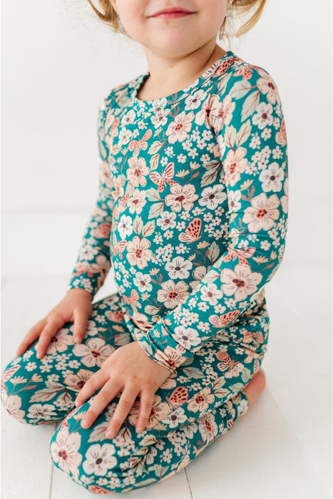 Child wearing a floral Pajamas set  with long sleeves and pants on a white background
