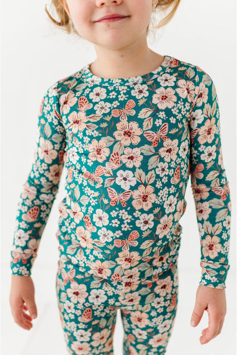 Child wearing Bird and Bean Floral pajama Top and Bottom  set with a white background 