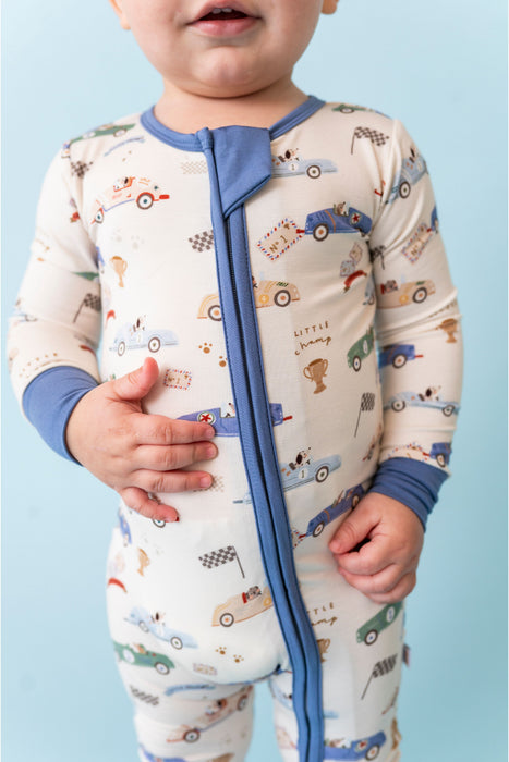 Baby wearing a pajama with car pattern on a light blue background - Bird and Bean Kids 