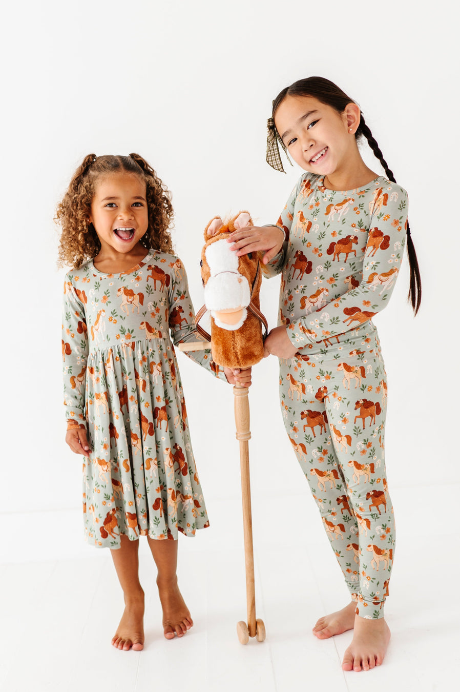 Two children wearing matching pajama sets with animal prints on a white background