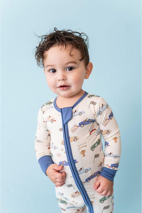 Baby wearing a patterned sleepsuit with blue accents against a light blue background - Bird and Bean Baby 