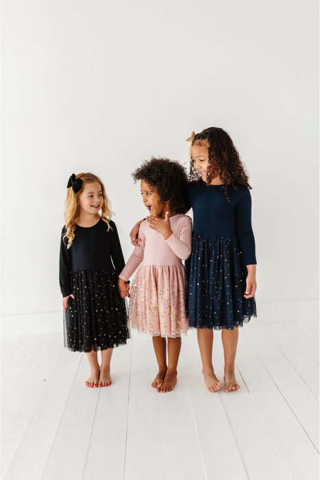 Three young girls wearing dresses standing on a white floor. | Bird and Bean Holiday