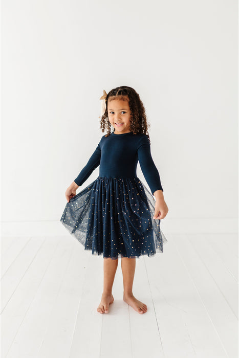 Young girl wearing a navy dress  with tulle sparkle skirt on a white background | Bird and Bean Holiday