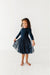 Young girl wearing a navy dress  with tulle sparkle skirt on a white background | Bird and Bean Holiday