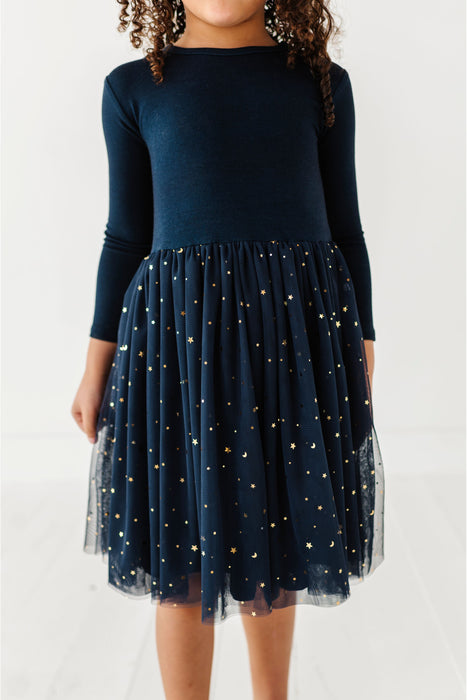Navy dress with a tulle overlay featuring star patterns on a white background | Bird and Bean Holiday