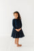 Young girl wearing a navy bamboo tulle dress with a white background| Bird and Bean Holiday