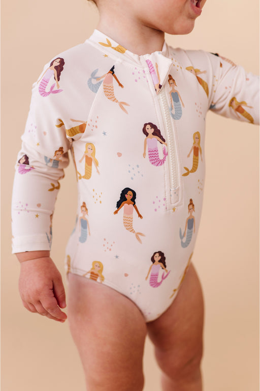 Child wearing a mermaid-themed swimsuit with a beige background Bird and  Bean