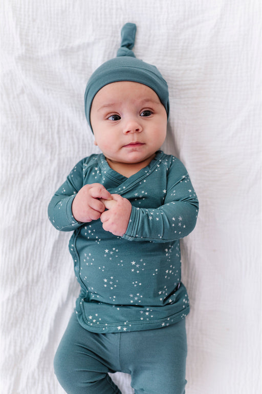 Baby wearing a matching bamboo outfit with a star pattern on a white background by Bird and Bean 