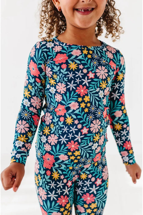 Another close up of child model in Bamboo Maren Peach, gold, and pink flower navy pajama set