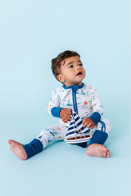 Baby Model holding toy boat wearing Kai Sailboat Print Bamboo One Piece Zip Romper
