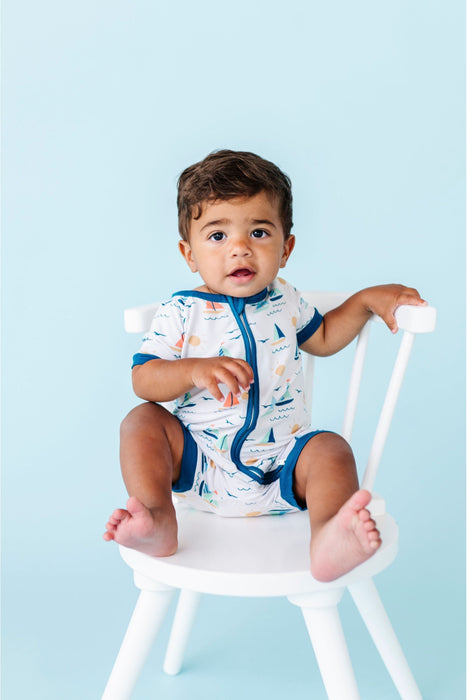 Baby Model sitting in chair wearing Bamboo Kai Sailboat Baby Shortie Romper Onesie