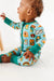 Baby model wearing bamboo zip up pajamas featuring bright, adorable illustrated adventure merit patches in Let's Explore print