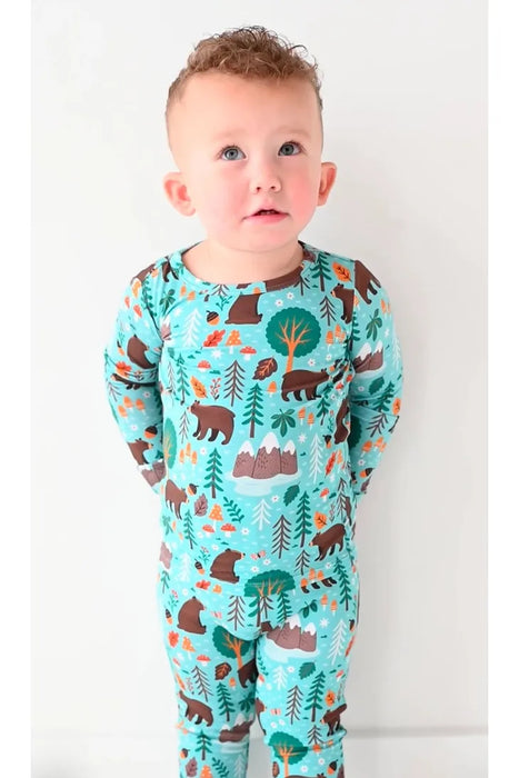 Boy model stands in green blue bamboo Woody Woodland Bear pajama set