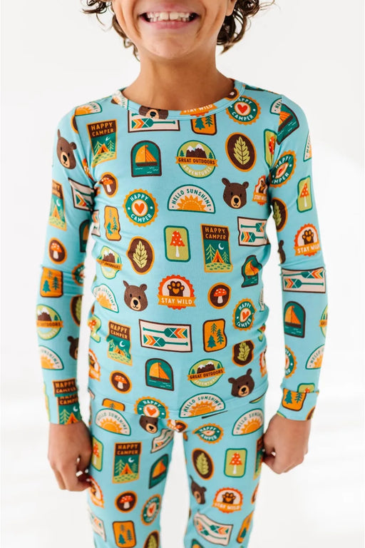 Child model wearing bamboo pajamas featuring bright, adorable illustrated adventure merit patches in Let's Explore print