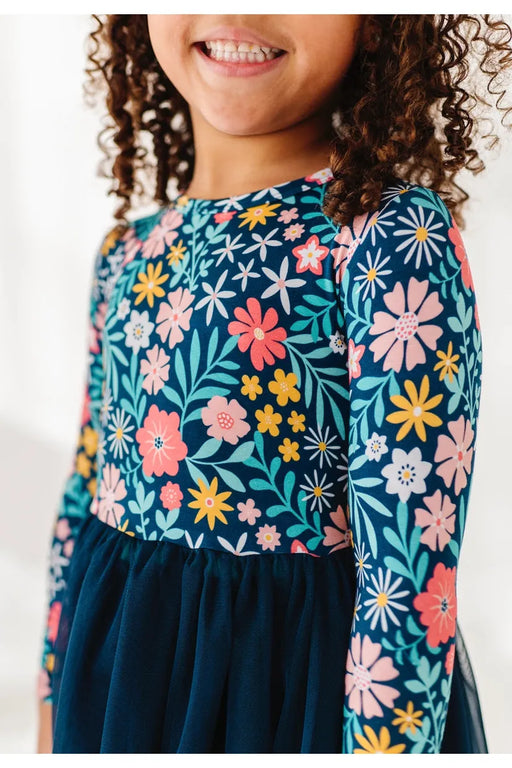 Close up of Child model in Maren Floral Navy Tulle Bamboo Dress with pink and gold flowers. 