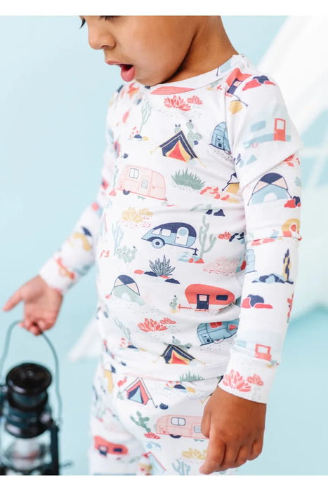 Close up of kid model wearing Bamboo Desert Adventure Happy Camper Tents and Cactus Kids Pajama Set holding lantern in front of studio set