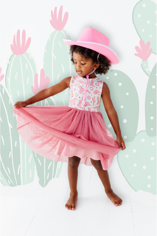Girl Model wearing Dixie Cowboy Western Pink Tank bamboo dress with tulle skirt with cactus designs layered behind her