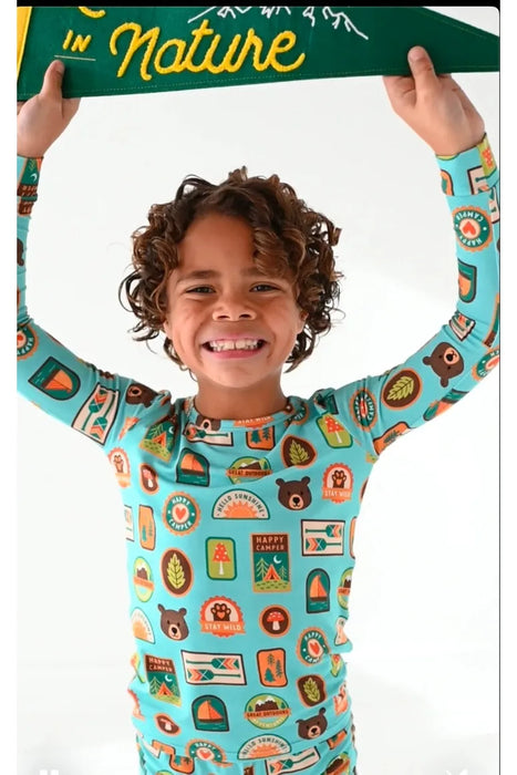Kid model wearing bamboo pajamas featuring bright, adorable illustrated adventure merit patches in Let's Explore print