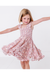 Young girl in a pink floral easter dress twirling on a white background bird and bean kids