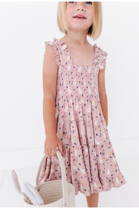 Young girl wearing a pink floral dress on a white background