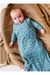 A baby lying on a chunky knit tan blanket, wearing a long-sleeve bamboo sleep sack in dusty blue with a white crescent moon pattern. Bird and Bean Baby 