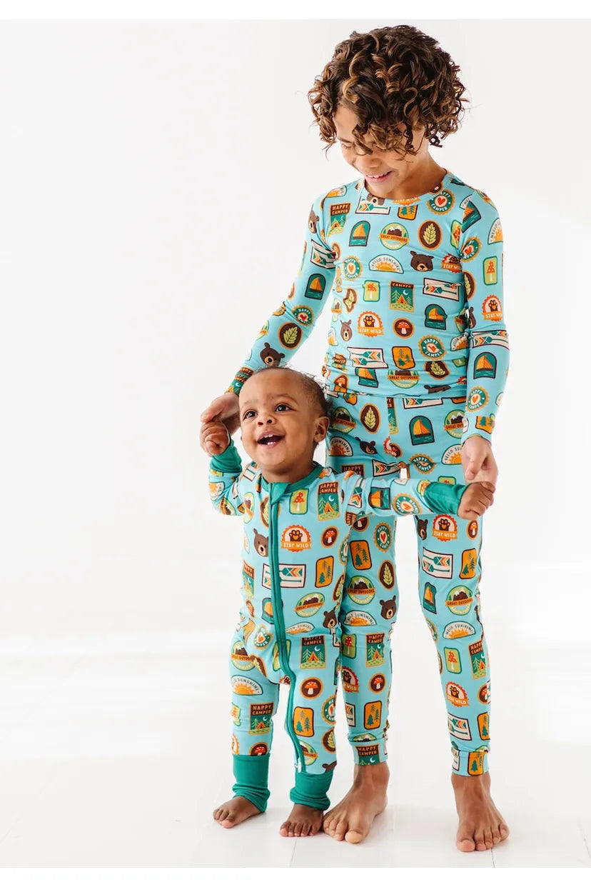 Two kids models wearing bamboo pajamas featuring bright, adorable illustrated adventure merit patches in Let's Explore print