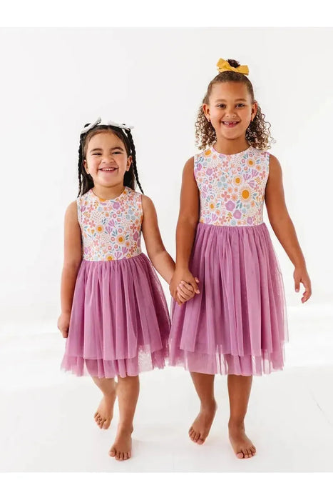 Two smiling kids wearing Darling Spring Daisy bamboo tulle dress with peach, lilac, golden, and sage blooms
