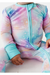 close up of astra one piece zip romper on baby model. moons and stars on pink and purple ombre background 