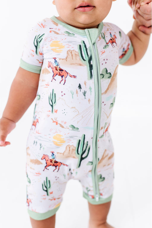 closeup of baby model wearing Bird & Bean Bamboo Shortie Romper Onesie with Billy Cowboy Western Print