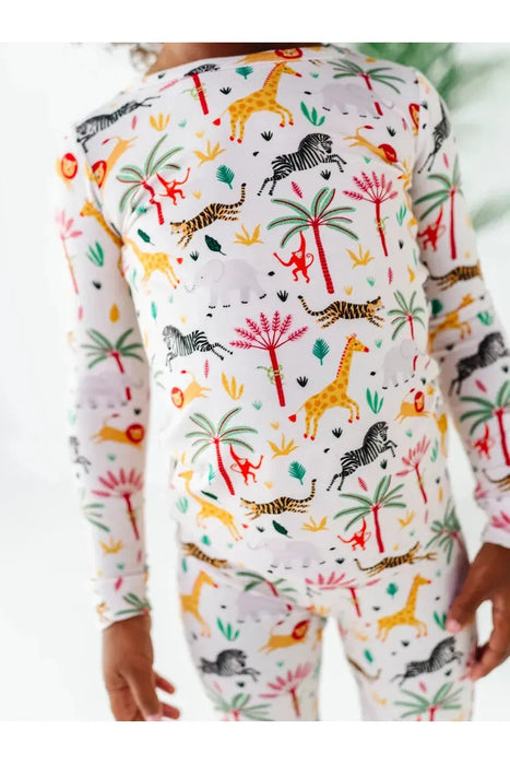 top half close up of kid model wearing Safari Animal print bamboo kid pajamas with zebra, lion, elephant, giraffe on cream background